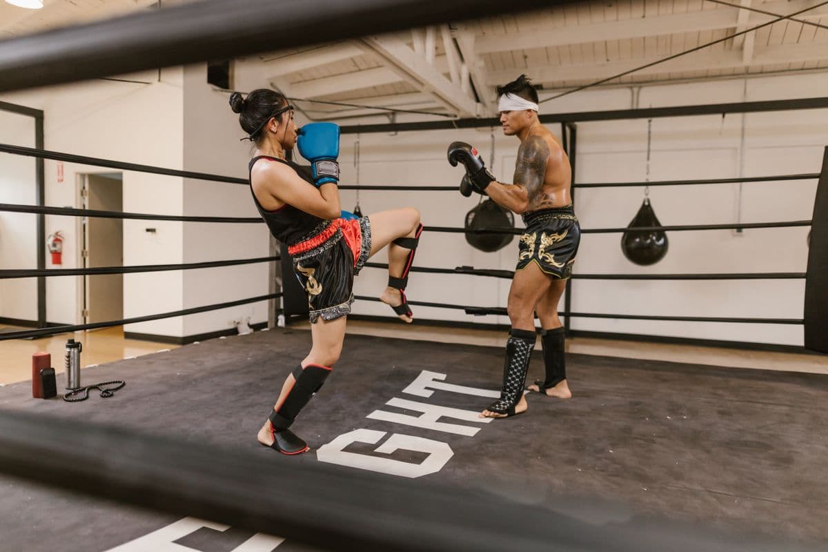 Two Muay Thai athletes sparring in a training ring