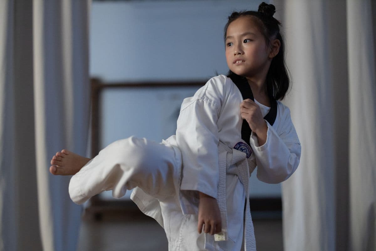 A young taekwondo student practicing a side kick