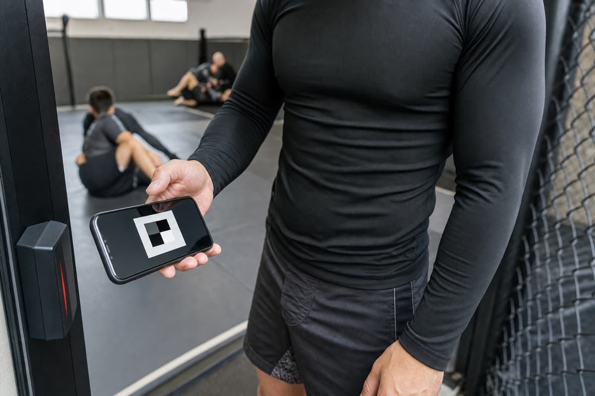A no-gi MMA student using a phone to check in at the academy entrance